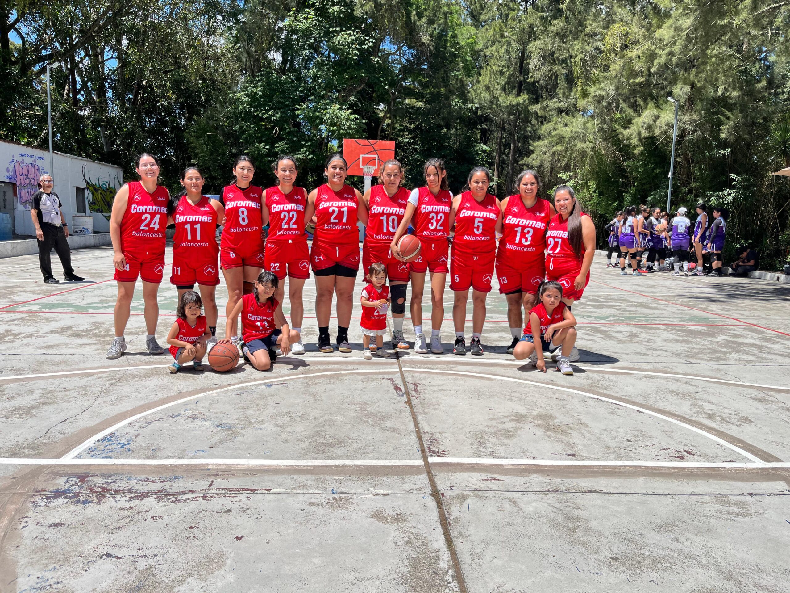 Equipo femenino Coromac de baloncesto en Guatemala posando en cancha al aire libre.